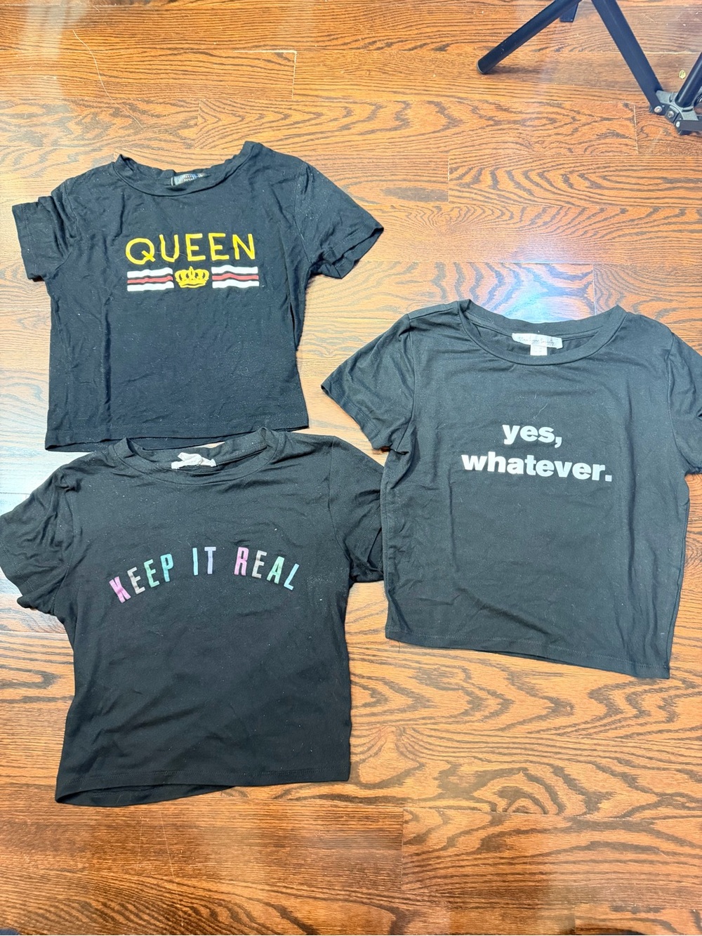 Three black graphic crop tops feature bold statement text S/M